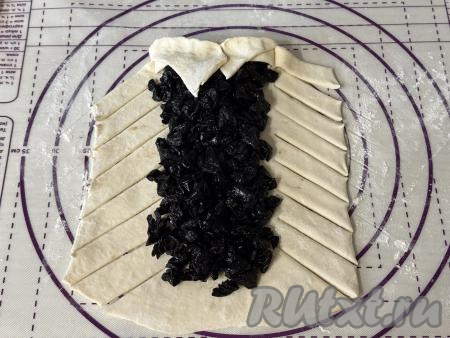 Завернуть верхний (узкий) край прямоугольного пласта теста на начинку, хорошо прижать тесто пальцами.&nbsp;