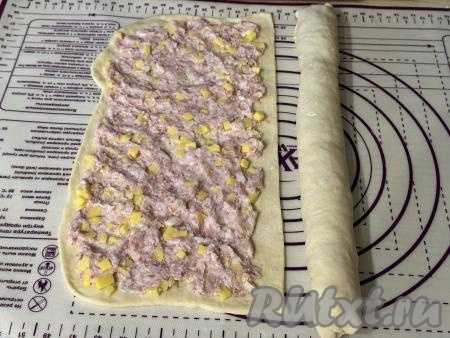 Начиная с более широкого края каждой части теста, свернуть тесто с начинкой в плотный рулет, скрепить края теста. В результате у нас получатся 2 рулета.&nbsp;