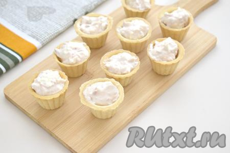 Получившуюся массу из консервированного тунца и творожного сыра перед подачей на стол раскладываем по тарталеткам. Я взяла маленькие тарталетки для икры, поэтому наполнила 15 тарталеток. Количество тарталеток, которое вы заполните, напрямую зависит от размера тарталеток. Заранее раскладывать массу по тарталеткам не нужно, чтобы тарталетки не размокли.