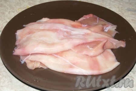 Приготовить сырые кальмары. Очистить их от внешних и внутренних пленок, опустив на 1 минуту в горячую воду, а затем сразу опустив в холодную и  промыв под проточной водой.