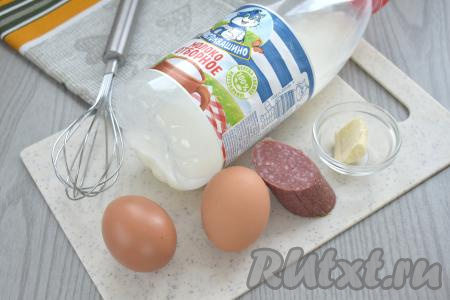 Подготовить продукты для приготовления омлета с колбасой в аэрогриле. Молоко можно взять любой жирности. Колбаса тоже подойдёт любая (варёная, полукопчёная или копчёная).