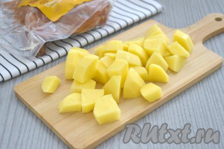 В кастрюлю наливаем 2 литра воды, ставим на сильный огонь, даём закипеть. Пока вода закипает, очищаем картошку, нарезаем на средние кубики.