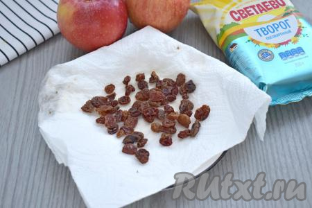 Изюм, если будете использовать, промываем водой, выкладываем в небольшую ёмкость, заливаем кипящей водой и оставляем минут на 5. Затем воду сливаем, а изюм выкладываем на бумажное полотенце и даём ему обсохнуть. Осматриваем изюм, если будут веточки или некачественные изюминки, их нужно будет удалить.