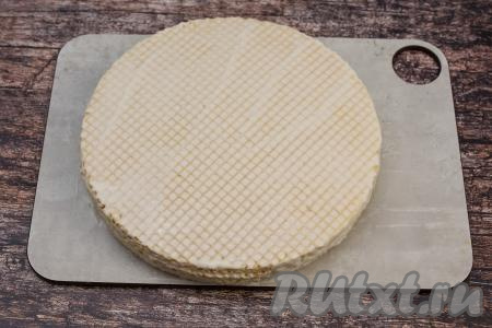 На смазанный корж выложить следующий вафельный корж, тоже смазать его сверху творожным кремом. Если есть повреждённые коржи, тогда их выложить в середину торта и смазать. Так, укладывая коржи и промазывая их кремом, собрать весь торт.&nbsp;Последний корж должен быть без повреждений, как и первый.&nbsp;Слегка прижать ладонью верхний корж. Смазать творожным кремом верх последнего коржа. Всего у меня были 8 вафельных коржей.&nbsp;Слегка промазать и бока торта оставшимся кремом. Торт&nbsp;из готовых вафельных коржей убрать на 3-4 часа в холодильник, чтобы он как следует пропитался. Я перед отправкой в холодильник торт накрываю сверху пластиковой крышкой для микроволновки.