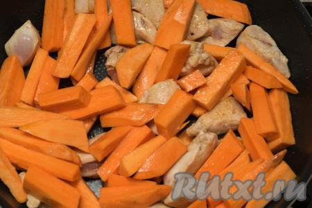 После того как мясо курицы приобретёт румяную корочку, уменьшить огонь до среднего, выложить в сковороду батат, влить ещё 1-2 столовых ложки масла.