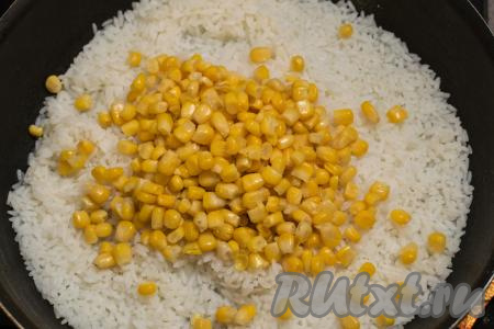 В сковороду с полностью готовым рисом добавить консервированную кукурузу без жидкости.