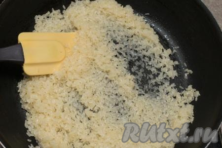 В сковороде прогреть растительное масло, выложить рис, обжарить его на среднем огне, помешивая, минуты 2.