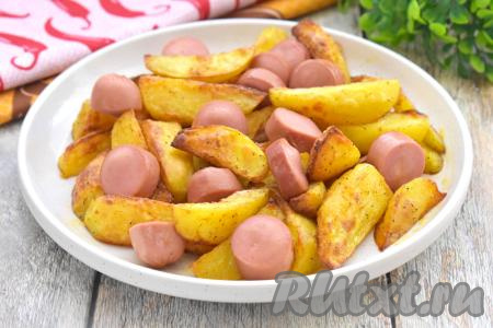 Готовую картошку с сосисками достаём из чаши аэрогриля, сразу же раскладываем по тарелкам и подаём к столу на обед или к ужину. Картофель в процессе запекания становится аппетитным, покрытым приятной корочкой снаружи и при этом нежным внутри, а сосиски делают это блюдо более сытным и вкусным.