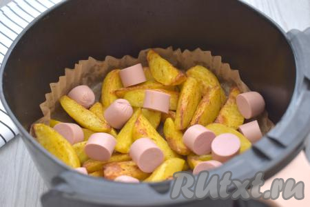 Отправляем картофель запекаться ещё на 10 минут, затем ещё раз перемешиваем и пробуем на готовность. Картошка должна быть уже практически готова (то есть она будет достаточно хорошо прокалываться вилкой). Если картошка ещё твердовата (многое зависит от сорта картофеля и величины нарезки), тогда продолжайте запекать ещё 5-10 минут, но в этому случае общее время запекания нужно будет увеличить. У меня картошка по прошествии 30 минут с момента начала запекания была практически готова. Когда картофель будет почти готов, добавляем к нему сосиски, очищенные от оболочки и нарезанные на небольшие кусочки, перемешиваем и запекаем оставшиеся 10 минут.