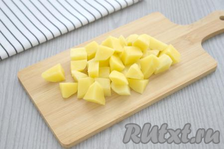 Наливаем в кастрюлю 2 литра воды, сразу ставим на сильный огонь. Пока вода закипает, очищаем картофель и нарезаем на небольшие кубики.