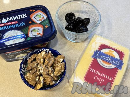 Подготовить продукты для приготовления сырных шариков с черносливом и грецкими орехами. Чернослив промыть водой, обдать кипятком, а затем обсушить, разложив его на бумажном полотенце.