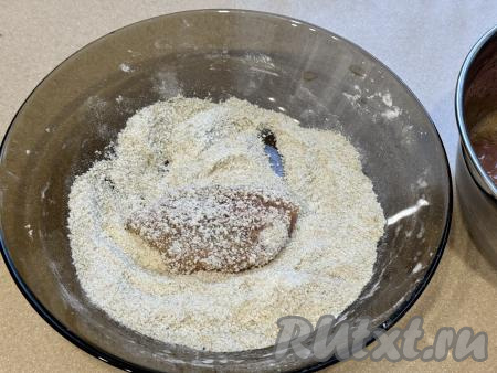 Обвалять кусочки свинины со всех сторон в смеси из панировочных сухарей и крахмала, получатся заготовки наггетсов. Обваливать в смеси крахмала и сухарей нужно столько кусочков мяса, сколько одновременно поместятся на сковороду.