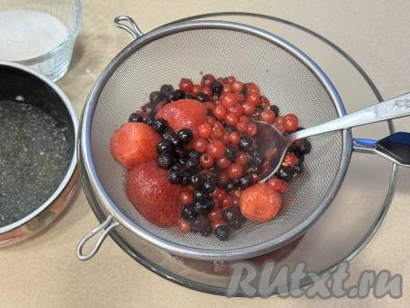Взять достаточно глубокую миску, поверх неё поставить сито. Вылить в сито ягоды вместе с жидкостью, в которой они варились. В миске будет процеженная жидкость, а в сите останутся ягоды. С помощью столовой ложки перетереть ягоды через сито в миску.&nbsp;