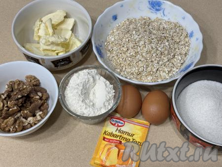 Подготовить продукты для приготовления овсяного печенья с грецкими орехами. Сливочное масло заранее достать из холодильника, чтобы оно успело нагреться до комнатной температуры. Овсяные хлопья можно взять любые быстрого приготовления (на упаковке хлопьев должно быть указано: время варки 5 минут).