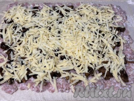 Поверх грибов равномерно распределить сыр, натёртый на крупной тёрке.