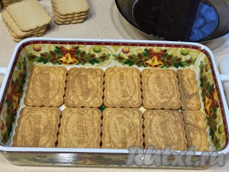 Печенье "Юбилейное", пропитанное кофе, сразу выкладывать первым слоем в подходящую квадратную или прямоугольную форму, в которой вы будете формировать тирамису. Я формировала в прямоугольной форме размером 27 сантиметров на 17 сантиметров. У меня каждый слой состоял из 8 целых печенюшек и 1 печенье я разрезала на части, полностью заполняя дно формы.