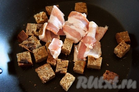 Хлеб нарезать средним кубиком, добавить нарезанный бекон и обжарить на сухой и хорошо раскаленной сковороде.