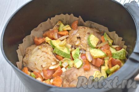 Через 20 минут с начала запекания достаём чашу из аэрогриля, куриные бёдра переворачиваем, овощи перемешиваем. Снова отправляем чашу в аэрогриль. Продолжаем запекать куриные бёдра с овощами ещё 20 минут.  После того как мясо и овощи запекутся в течение 40 минут, нужно проверить готовность. Готовые овощи должны легко прокалываться ножом, а при прокалывании бёдрышек должен выделяться прозрачный сок. Если мясо или овощи не готовы, нужно овощи перемешать, мясо при необходимости перевернуть и запекать в аэрогриле ещё 5-10 минут. У меня аэрогриль мощностью 1400 Ватт, я запекала бёдра с овощами до готовности 40 минут.