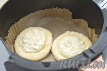 Застилаем чашу аэрогриля пергаментом. Немного смазываем пергамент растительным маслом, затем выкладываем аккуратно ватрушки. Поскольку чаша аэрогриля небольшая, у меня в неё поместились&nbsp;только 2 ватрушки из слоёного теста.&nbsp;Чашу с ватрушками отправляем в аэрогриль (мощность моего аэрогриля 1400 Ватт), температуру выставляем на 160 градусов, а время - на 25 минут.