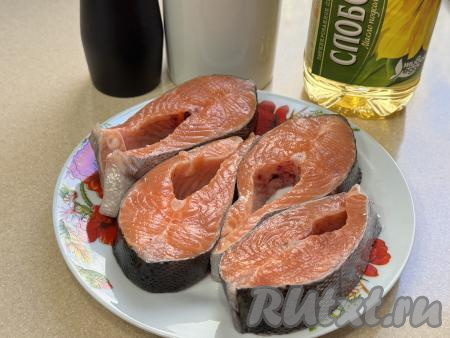 Подготовить продукты для приготовления стейков из форели на сковороде гриль. Стейки из форели промыть водой, обсушить бумажным полотенцем. Если у вас стейки замороженные, тогда предварительно их следует разморозить. Если вы купили форель целиком, тогда её нужно будет разморозить, выпотрошить, отрезать голову и плавники, хорошо промыть водой и нарезать на стейки толщиной примерно 2,5-3 сантиметра.