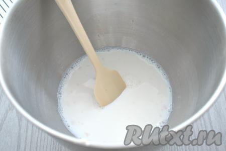 Молоко на плите (или в микроволновке) подогреваем до 38-40 градусов (если молоко будет более горячим, дрожжи в нём могут погибнуть). Вливаем тёплое молоко в миску. Хорошо перемешиваем лопаткой (или столовой ложкой), чтобы дрожжи и сахар растворились. Миску накрываем крышкой и ставим в тёплое место на 20 минут. За это время дрожжи активируются, образуя на поверхности пышную "шапку".