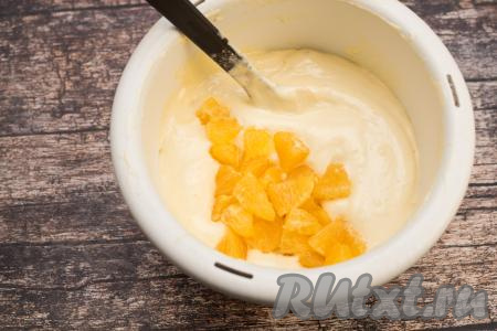 Нарезанные апельсины добавить в миску с замешанным бисквитным тестом.