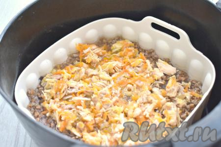 После того как гречка проварится в аэрогриле в течение 15 минут, прозвучит звуковой сигнал. Достаём чашу из аэрогриля, в форму с гречкой выкладываем тушёнку с обжаренными овощами, перемешиваем, отправляем в аэрогриль.