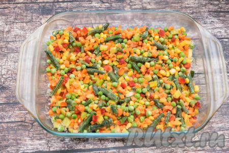 Мексиканскую смесь, не размораживая, выложить поверх риса, равномерно распределив по всей форме.