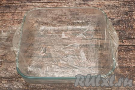 Дно формы застелить пищевой плёнкой так, чтобы края плёнки свисали с двух боков формы. Я взяла стеклянную квадратную форму с размером стороны 21 сантиметр.