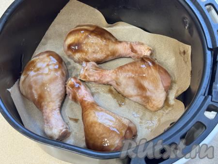 Решётку в чаше аэрогриля застелить пергаментом, выложить куриные ножки, замаринованные в соусе "Терияки". Отправить чашу в аэрогриль.