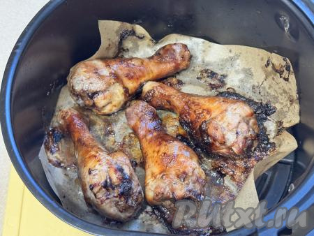 Выставить температуру 200 градусов, время - 5 минут. По прошествии 5 минут с начала запекания достать чашу из аэрогриля, перевернуть куриные ножки, снова отправить в аэрогриль, запекать ещё 5 минут при температуре 200 градусов. Затем ножки снова перевернуть, снизить температуру до 160 градусов. Запекать ножки в соусе "Терияки" ещё 20 минут (до готовности мяса), периодически переворачивая их, чтобы они равномерно пропеклись. Для того чтобы проверить готовность, сделайте на мясе разрез, если разрез светлый, на нём нет примесей крови, значит ножки готовы. Если же в разрезе присутствуют примеси крови, значит запекайте ножки ещё 5-10 минут при температуре 160 градусов.