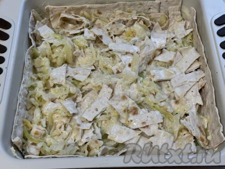 Выложить начинку из лаваша и капусты в форму, застеленную лавашами, равномерно распределить.