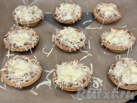 Поставить противень с тарталетками с фаршем и сыром&nbsp;в разогретую до 200 градусов духовку, запекать 10 минут.&nbsp;