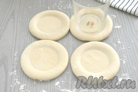 С помощью дна стакана (я взяла стакан с диаметром дна&nbsp;6 сантиметров) делаем в центре круглых заготовок из теста углубления.