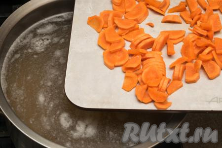 В процессе варки чечевицы до готовности количество бульона в кастрюле значительно уменьшается, поэтому нужно добавить в кастрюлю 500-800 миллилитров воды. Дать бульону закипеть, добавить в кастрюлю очищенную морковку, нарезанную на тонкие полукружочки.