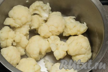 Снять кастрюлю с отваренной цветной капустой с огня, воду слить, оставить капусту остывать. Кастрюлю, в которой остывает варёная капуста, я крышкой не накрываю, чтобы капуста не переварилась. При желании варёную капусту можно из кастрюли переложить в миску, тогда она остынет немного быстрее.