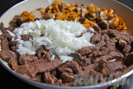 Отправляем к мясу заранее отваренные грибы (лисички многие не варят, а сразу жарят, я предпочитаю их проварить минут 15) и мелкорубленый лук. Солим, перчим по вкусу. Обжариваем минут 10 на сливочном масле.