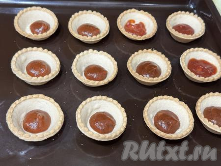 12 тарталеток поставить на противень. На дно каждой тарталетки выложить по 1 чайной ложке кетчупа.