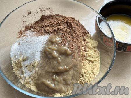 В миску с крошкой из печенья добавить банан, измельчённый в пюре, всыпать какао и сахар.