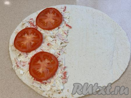 Помидоры нарезать на кружочки и выложить поверх крабовой начинки. Можно помидоры чуть подсолить.