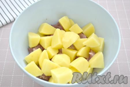 Картофель очищаем. 400 грамм очищенного картофеля нарезаем на средние кубики, добавляем в миску с кусочками свинины.