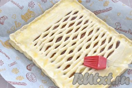 В небольшой ёмкости (например, в стакане) взбиваем яичный желток вилкой до однородности. Получившейся яичной смесью смазываем поверхность пирога.