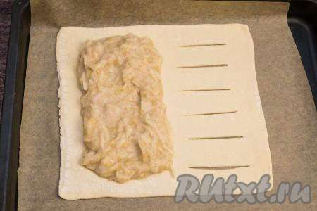 Противень застелить пергаментом. Перенести раскатанное тесто на застеленный противень. На сторону без надрезов равномерно выложить начинку из банана и яблока, отступив от краёв теста примерно по 2 сантиметра, как на фото.