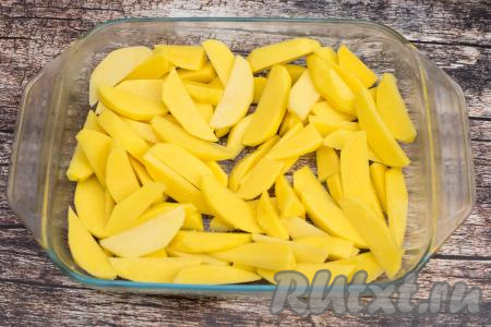 Картошку тоже очистить, промыть водой, нарезать на средние дольки. Выложить нарезанную картошку в форму для запекания.