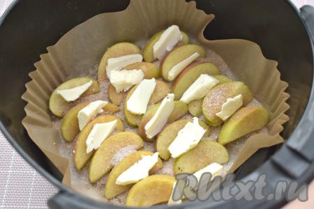 Поверх яблочных долек раскладываем сливочное масло, нарезанное на маленькие кусочки. Отправляем чашу с яблоками в аэрогриль.