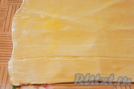 Яйцо взбить вилкой и тщательно смазать им тесто.