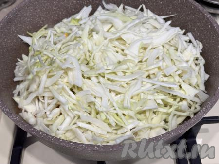 К обжаренным овощам выложить нарезанную капусту, сразу перемешать. Жарить капусту на огне выше среднего минут 5-7 (капуста должна немного обмякнуть, уменьшившись в объёме), иногда перемешивая.