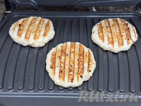 Закрыть створки электрогриля и готовить куриные котлеты примерно 7 минут.