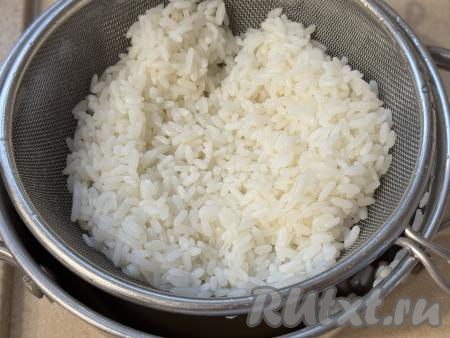 Рис промыть под проточной водой, затем выложить в кастрюлю с кипящей подсоленной водой, перемешать, дать закипеть и варить на небольшом огне до готовности (минут 20). Сварившийся рис откинуть на сито, лишней воде дать стечь. Оставить рис остывать. Для приготовления ленивых голубцов можно взять и грамм 120 варёного риса, оставшегося с обеда или ужина.