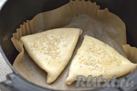 Застилаем чашу аэрогриля пергаментом, выкладываем самсу "швом" вниз. В небольшой ёмкости взбиваем вилкой до однородности яйцо. Поверхность самсы смазываем взбитым яйцом, посыпаем кунжутом. У меня уместились в чашу аэрогриля только 2 самсы, поэтому я готовила её в 2 захода.